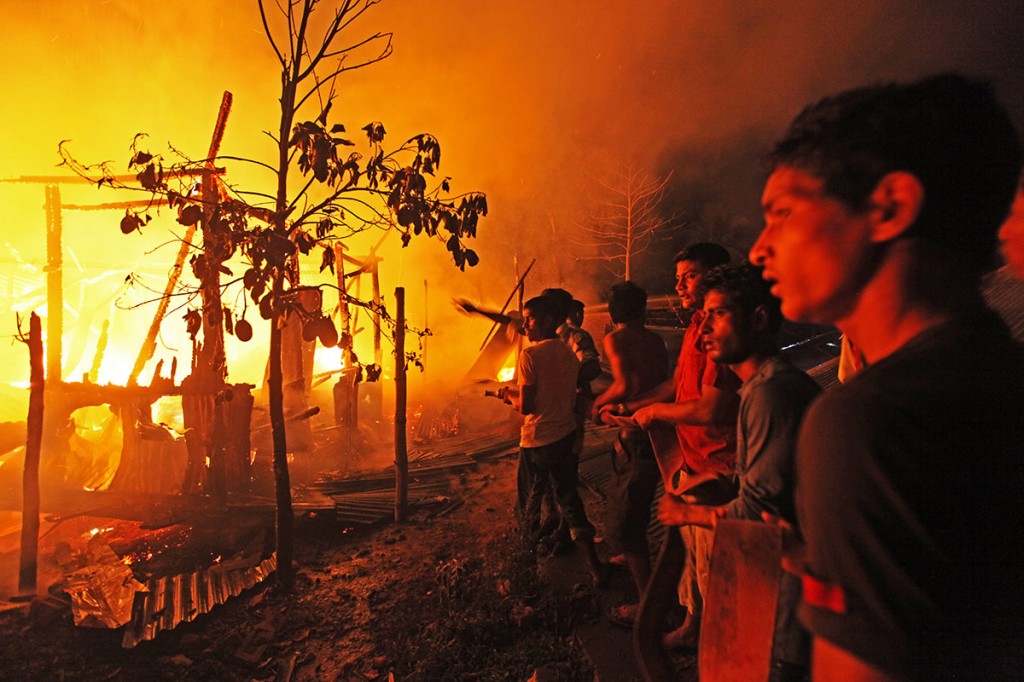 As the fire is prevented from spreading, onlookers search for signs of survivors. Photo: Shahidul Alam/Drik/Majority World