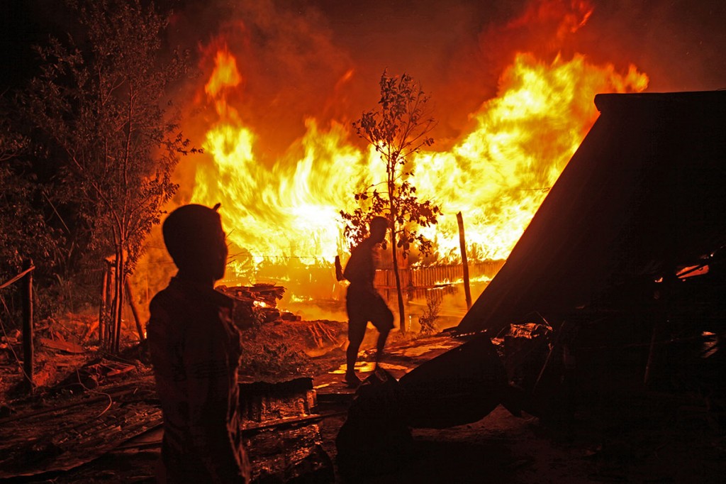 Neighbours quickly gathered to try and douse the fire. Photo: Shahidul Alam/Drik/Majority World