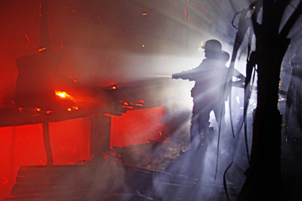 Firemen put out the last embers. No one was injured. Photo: Shahidul Alam/Drik/Majority World