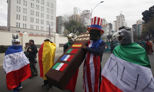 Demonstrators wearing donkey masks and draped in the flags of France, Spain, the U.S. and Italy carry a coffin outside the U.S. embassy in La Paz, Bolivia, on July 8 after Bolivia's President Evo Morales' plance was forced to stop in Vienna. Photo:Juan Karita/AP