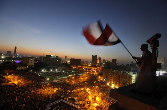 An Egyptian protester waves the national flag over Tahrir Square as opponents of President Mohammed Morsy gather, on June 28. Photo:Amr Nabil/AP