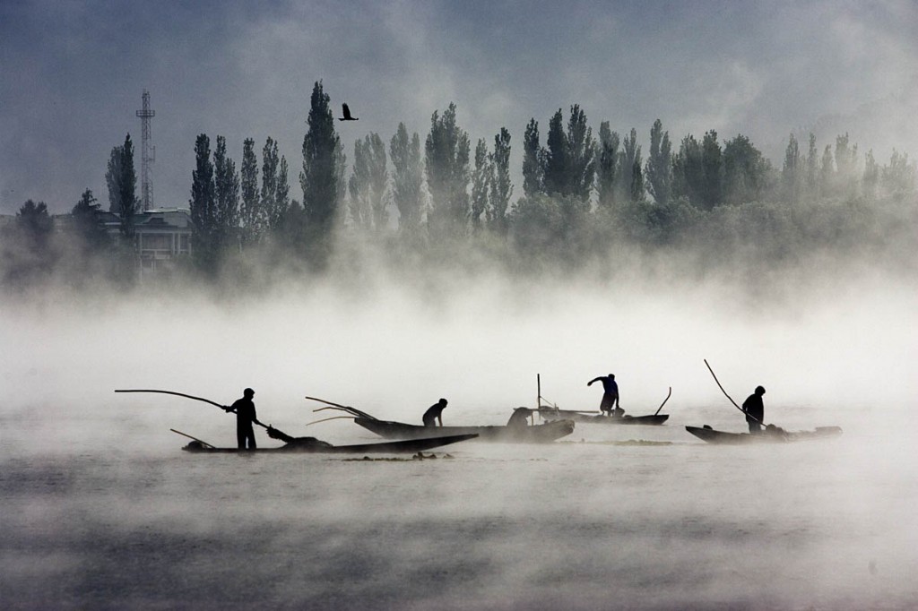 Boatmen fish in the early morning mist in Dal Lake. Srinagar. Kashmir. India. ? Shahidul Alam/Drik/Majority World