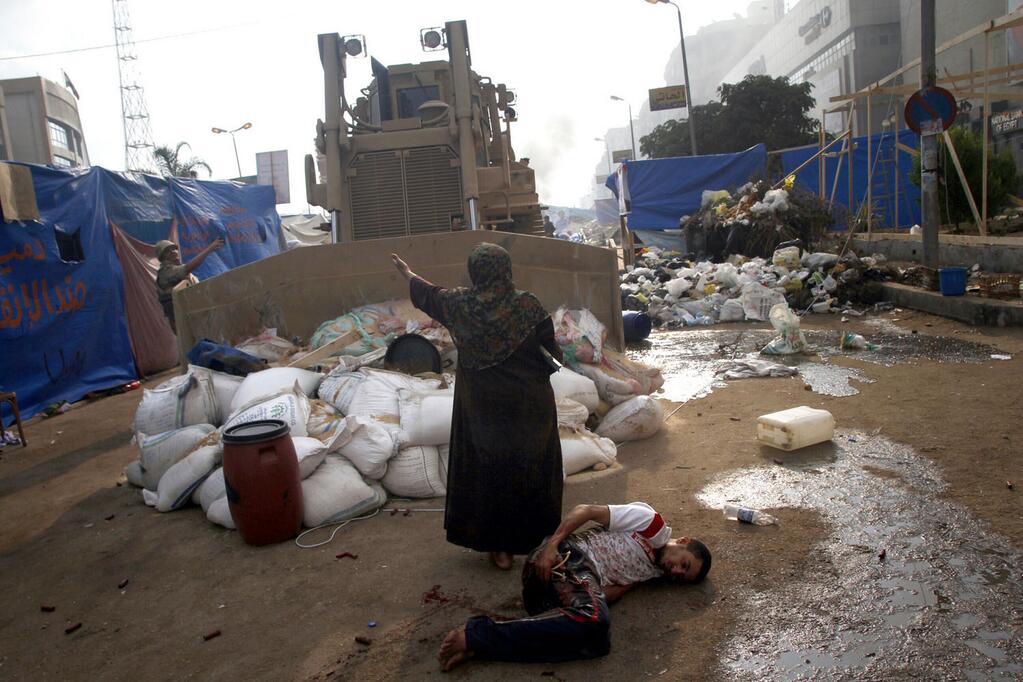 Woman facing down bulldozer, standing over wounded Morsi supporter @AFP Mohammed Abdel Moneim 