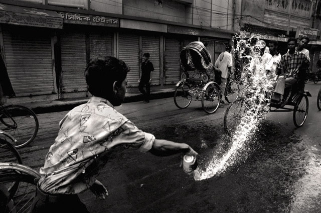 Shop helper settling the dust in early morning, Bongshal, 2006.