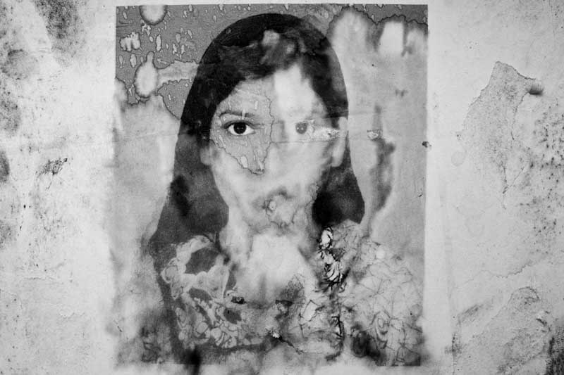 Photograph of Asma Akhter, a missing Rana Plaza garment worker, washed-out in the rain. Adhar Chandra High School wall, Savar, Dhaka. May 7, 2013. Photo ? Suvra Kanti Das