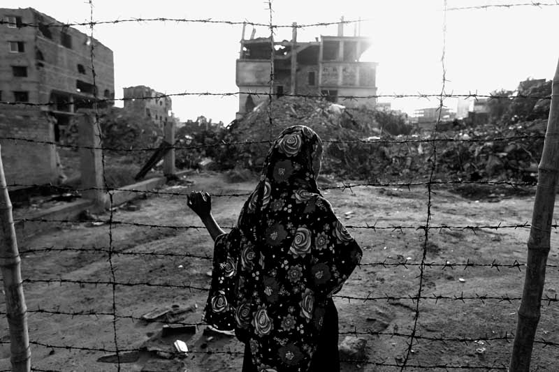 Rehana, a Rana Plaza survivor, rescued after being trapped for six hours, visits the building site. Savar, Dhaka. June 14, 2013. Photo ? Abir Abdullah