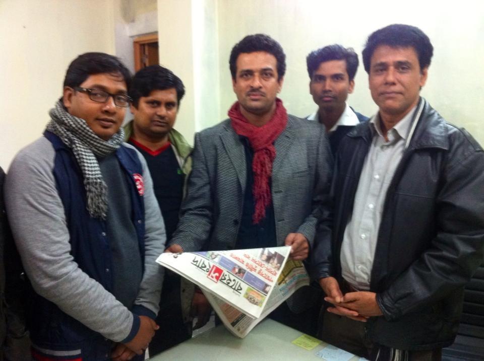 Azizur Rahim Peu (on right) and colleagues with a copy of the daily newspaper he edited Baher Shongbad