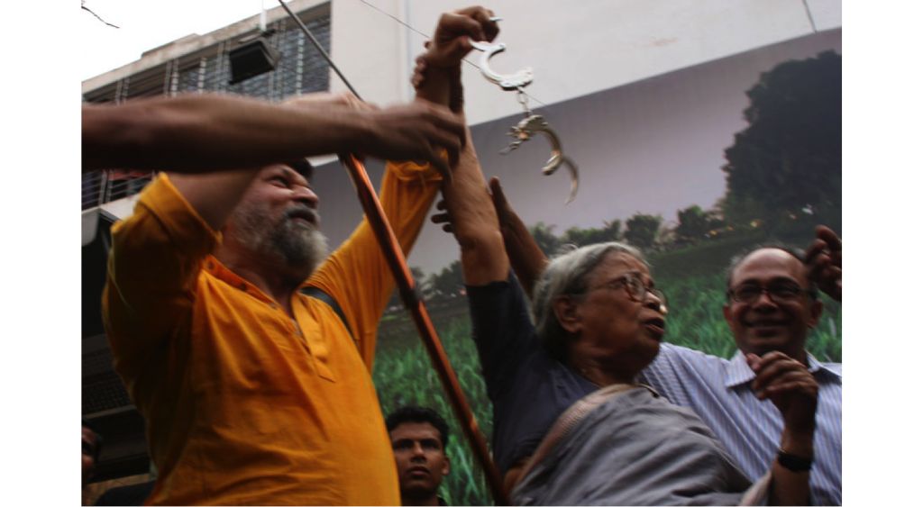 Mahasweta Devi removing handcuffs from Shahidul Alam at symbolic opening of "Crossfire" exhibition outside Drik. Photo: Drik